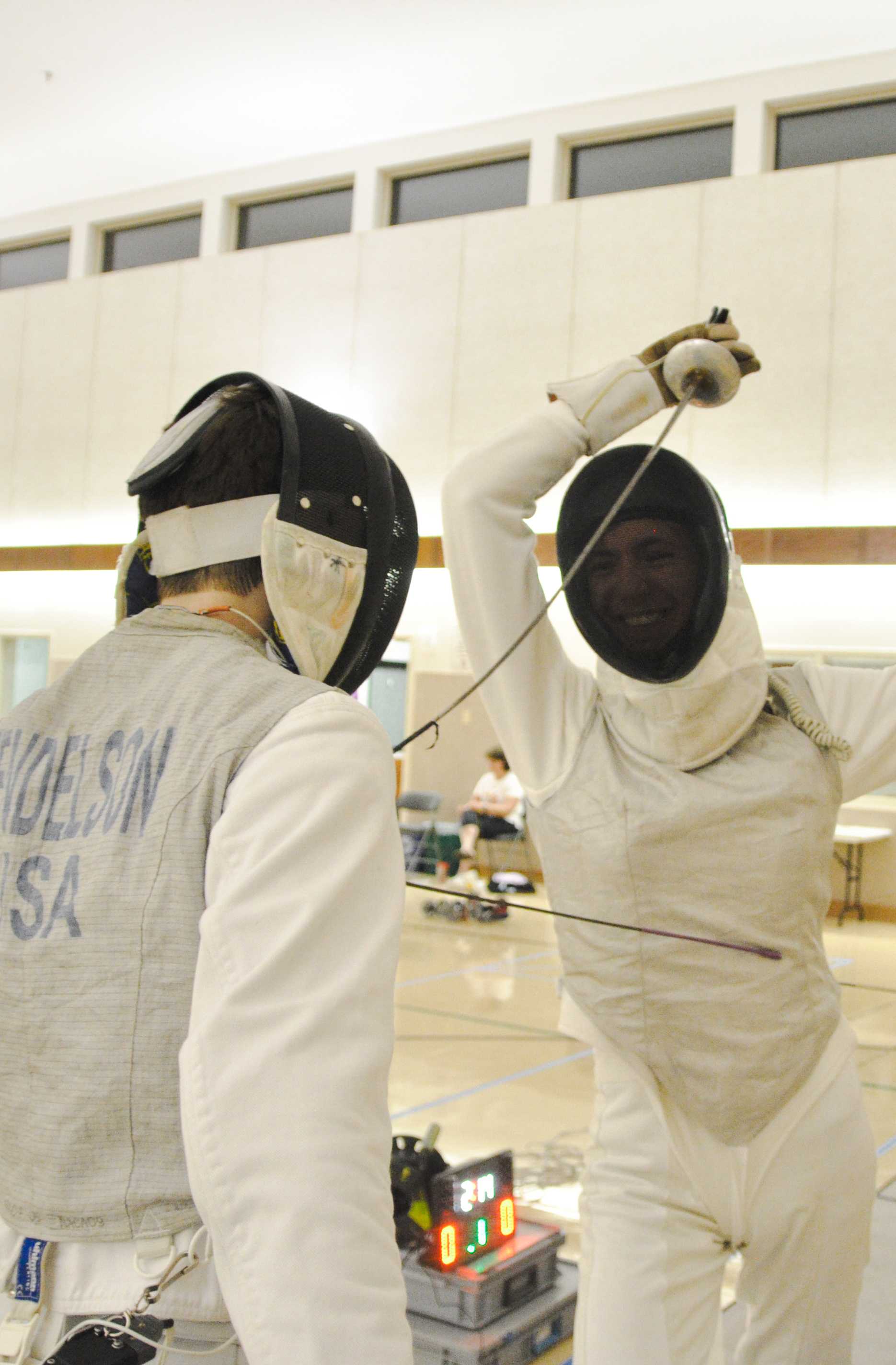 Two fencers in their whites after a bout